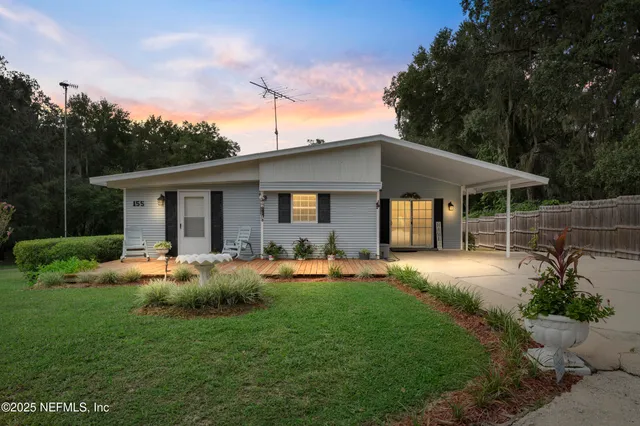 a front view of a house with patio and garden