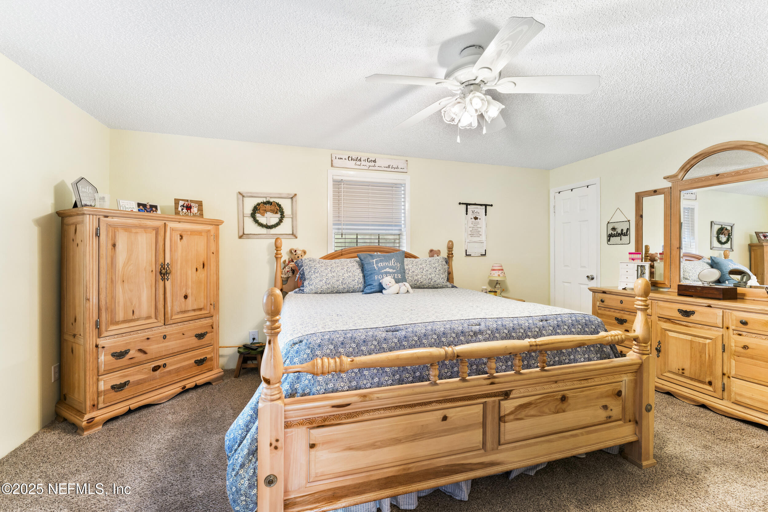 155 Tompkins Road Pomona Park, FL 32181 - Photo 12 of 38 a spacious bedroom with a bed and a chandelier
