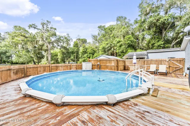 a view of a green field with trees in the background