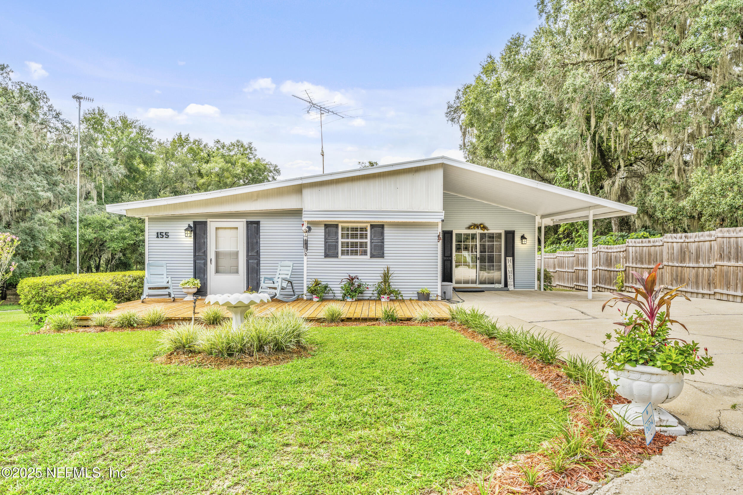 155 Tompkins Road Pomona Park, FL 32181 - Photo 4 of 38 a front view of a house with a yard table and chairs