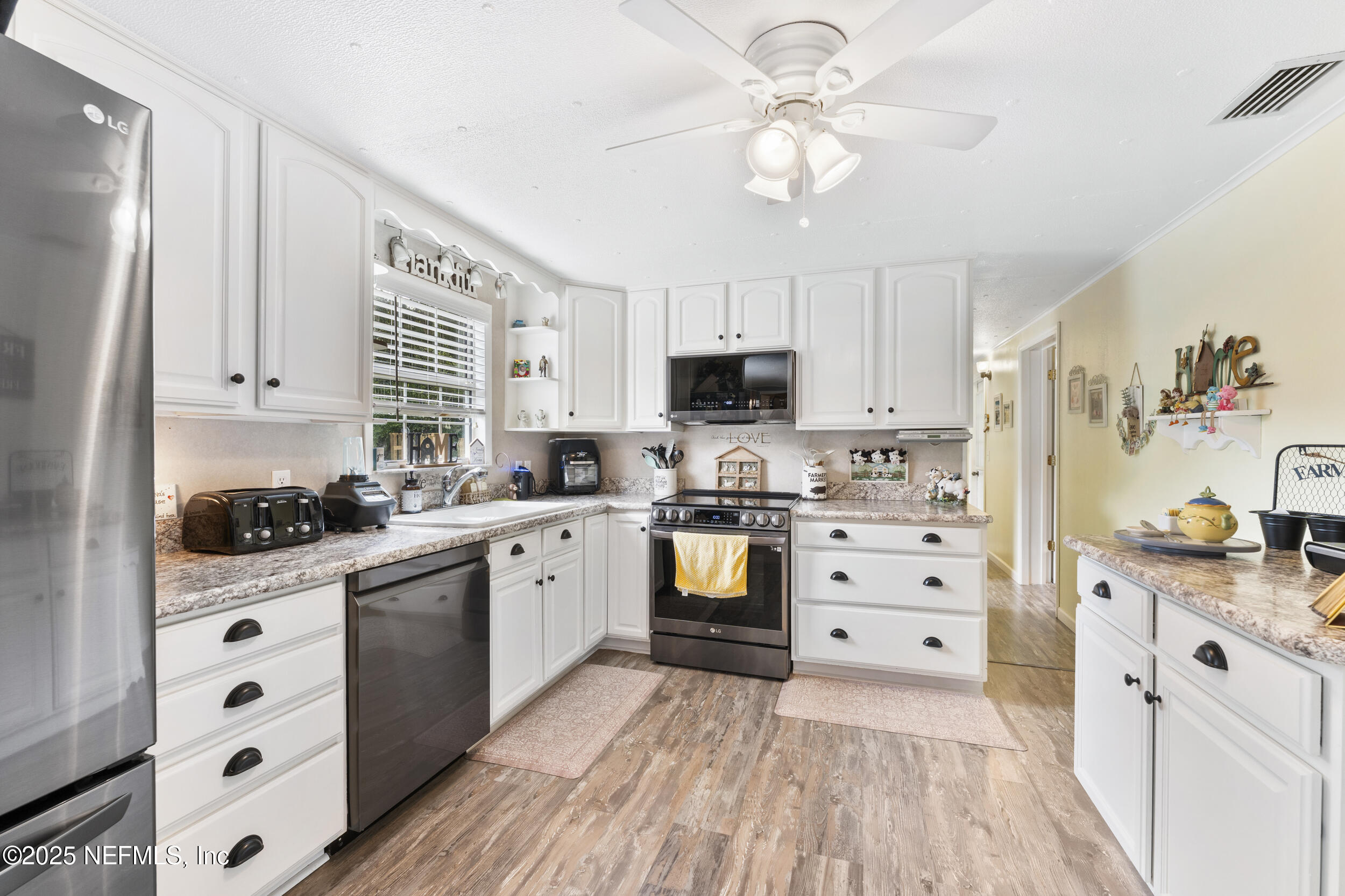 155 Tompkins Road Pomona Park, FL 32181 - Photo 9 of 38 a kitchen with stainless steel appliances a stove a sink cabinets and a window