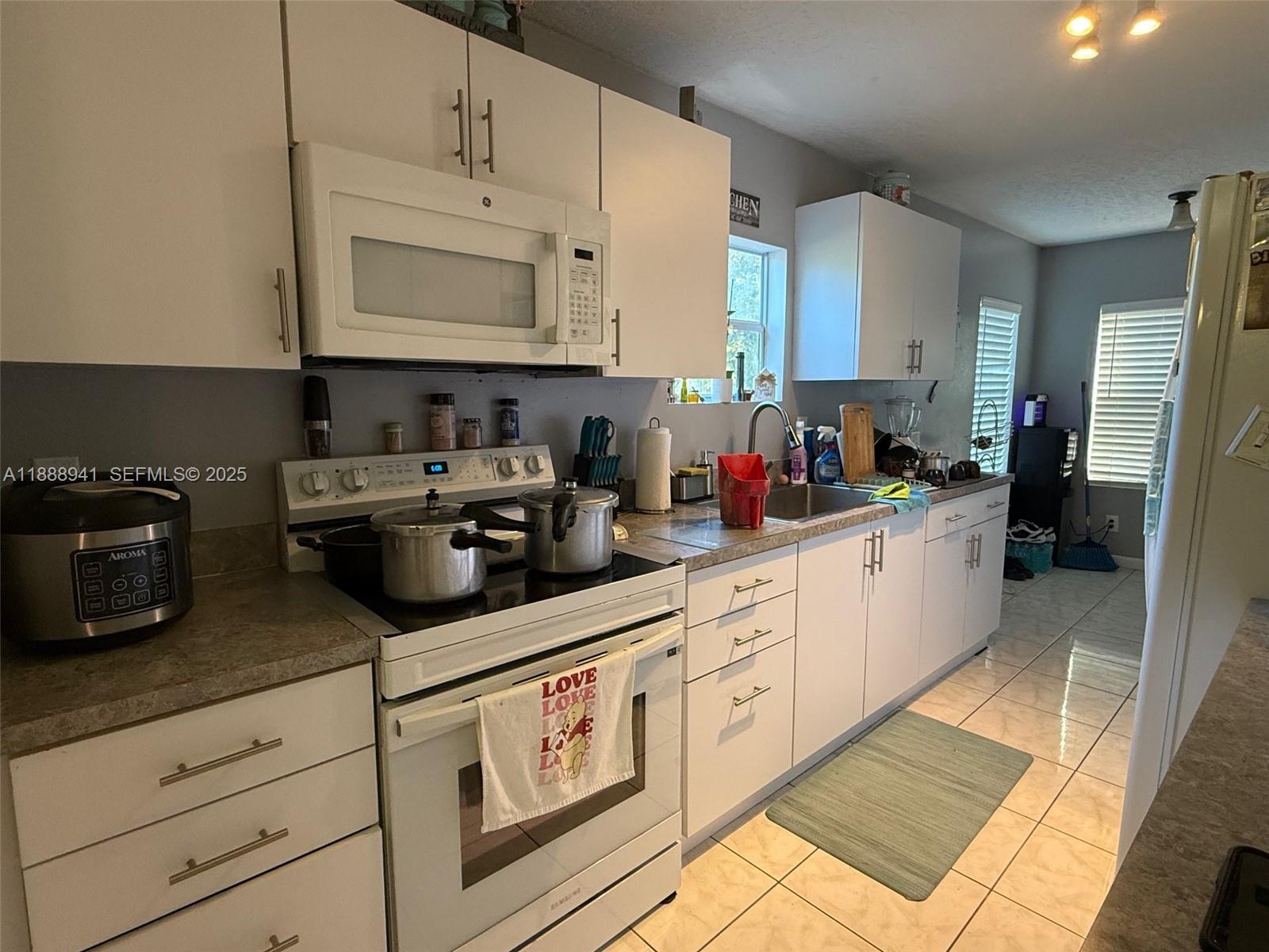 120 South Nogal Street Clewiston, FL 33440 - Photo 3 of 41 a kitchen with stainless steel appliances white cabinets and a sink