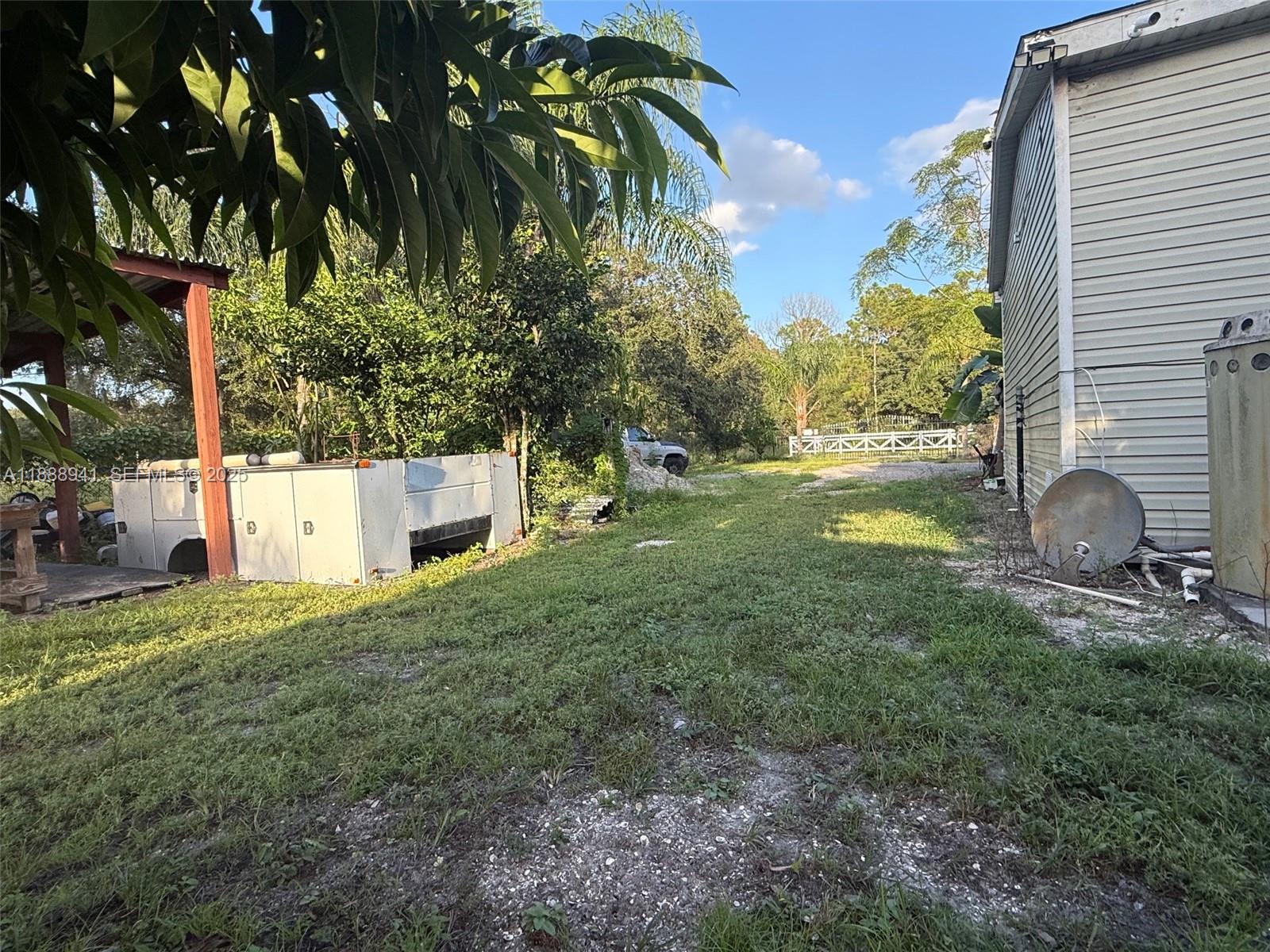 120 South Nogal Street Clewiston, FL 33440 - Photo 32 of 41 a backyard of a house with table and chairs