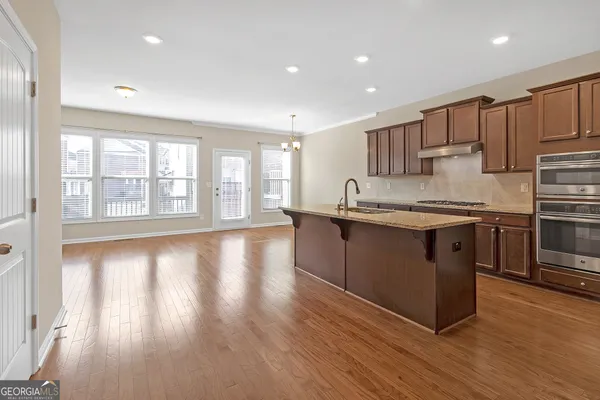 a kitchen with stainless steel appliances granite countertop a stove a sink and a refrigerator