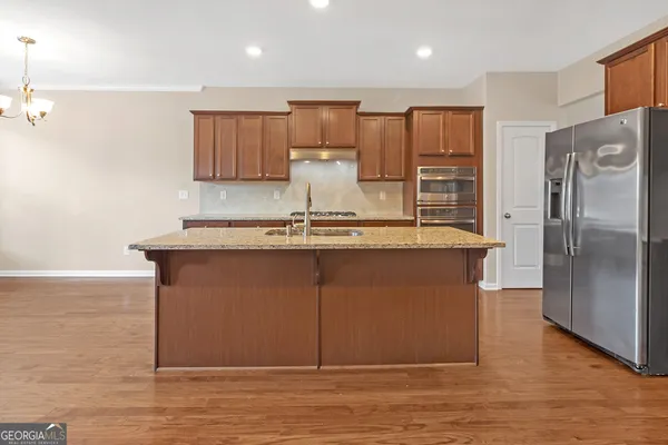 a kitchen with kitchen island a counter top space cabinets and stainless steel appliances