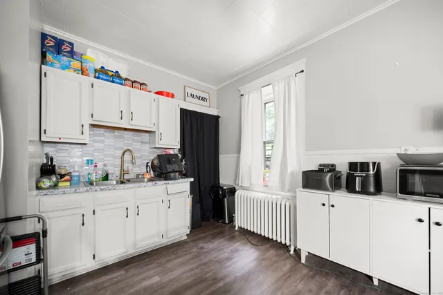 a kitchen with white cabinets and sink