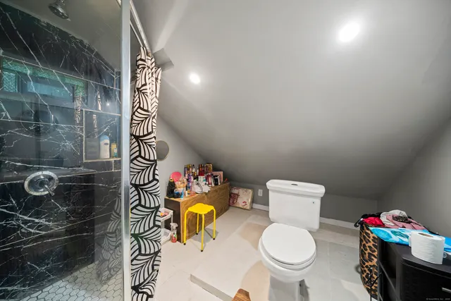 a bathroom with a toilet and a shower