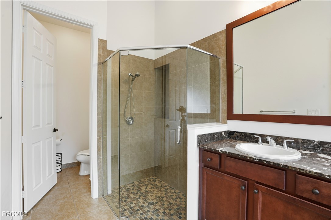5355 Ferrari Avenue Ave Maria, FL 34142 - Photo 14 of 28 a bathroom with a granite countertop sink mirror and a shower