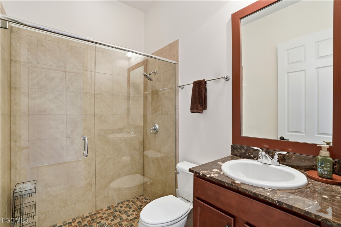 5355 Ferrari Avenue Ave Maria, FL 34142 - Photo 21 of 28 a bathroom with a granite countertop sink toilet a mirror and shower