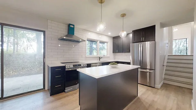 a view of an empty room and a chandelier fan