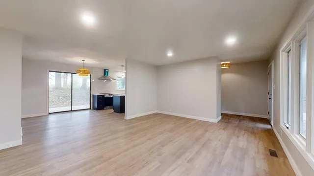 a view of an empty room with a fireplace and a window