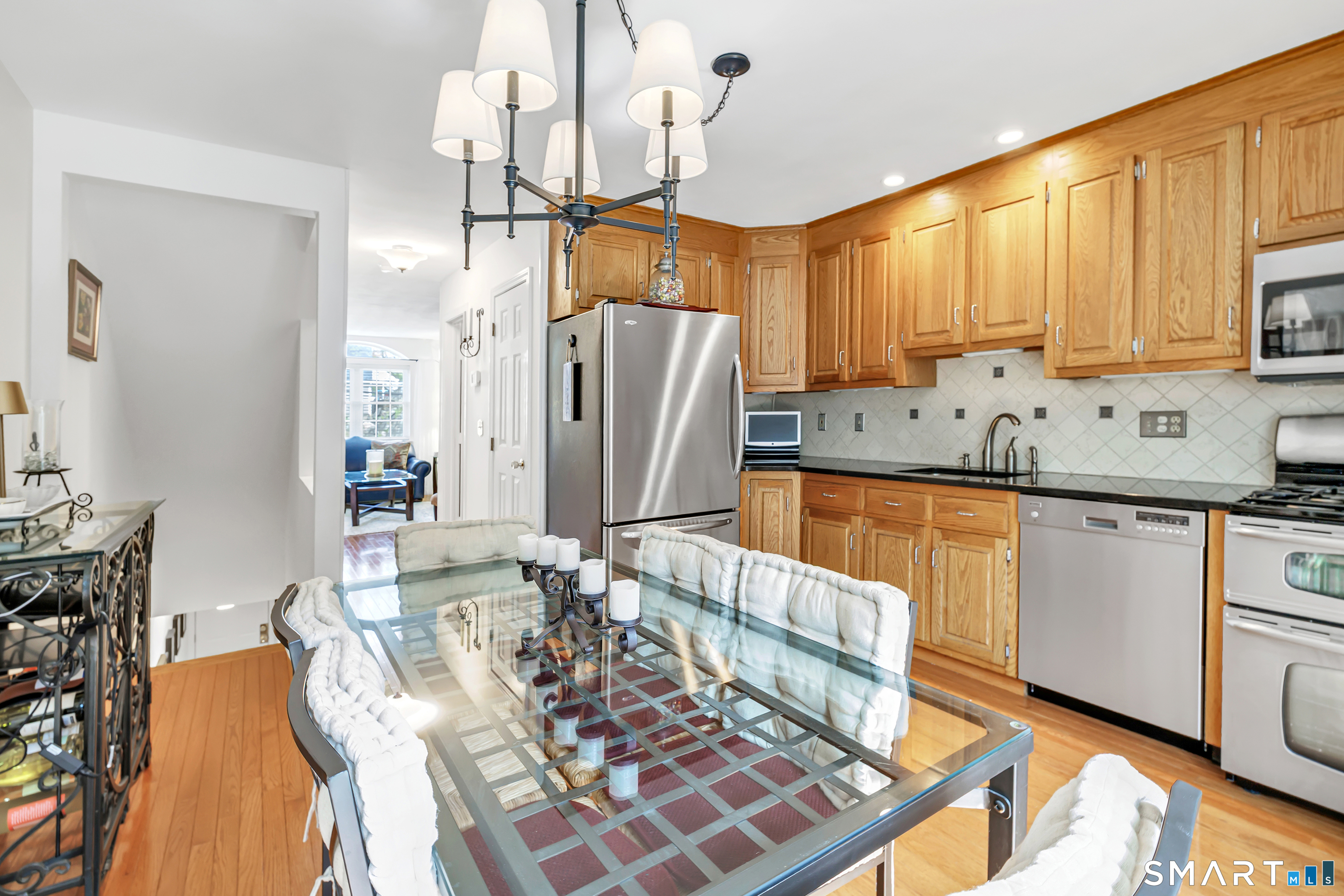 146 Howe Avenue, Unit 146 Shelton, CT 06484 - Photo 11 of 35 a kitchen with stainless steel appliances granite countertop a refrigerator a stove a sink dishwasher and white cabinets with wooden floor