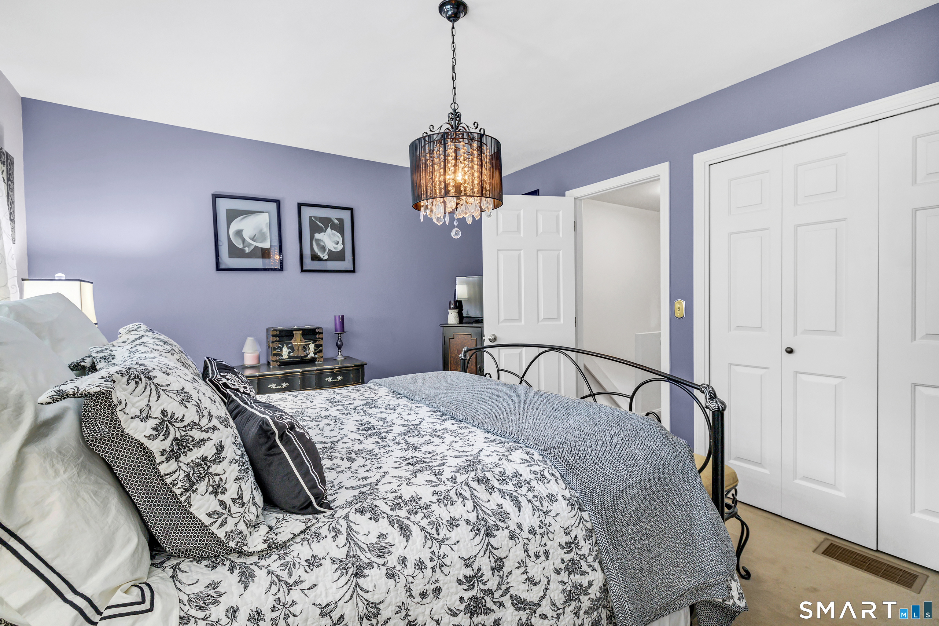 146 Howe Avenue, Unit 146 Shelton, CT 06484 - Photo 23 of 35 a bedroom with a bed and a chandelier