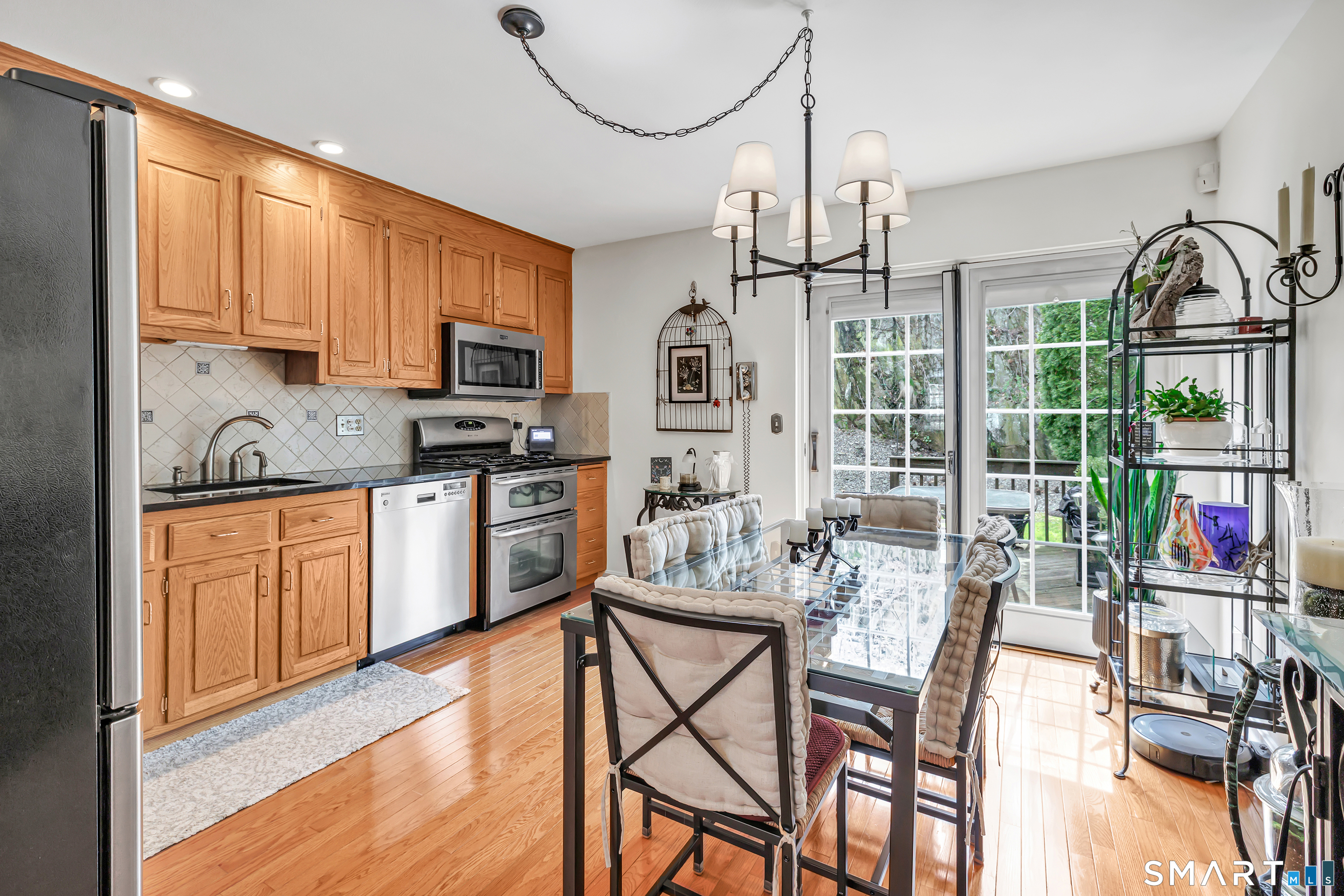 146 Howe Avenue, Unit 146 Shelton, CT 06484 - Photo 5 of 35 a kitchen with stainless steel appliances granite countertop a refrigerator a stove top oven a sink dishwasher and white cabinets with wooden floor
