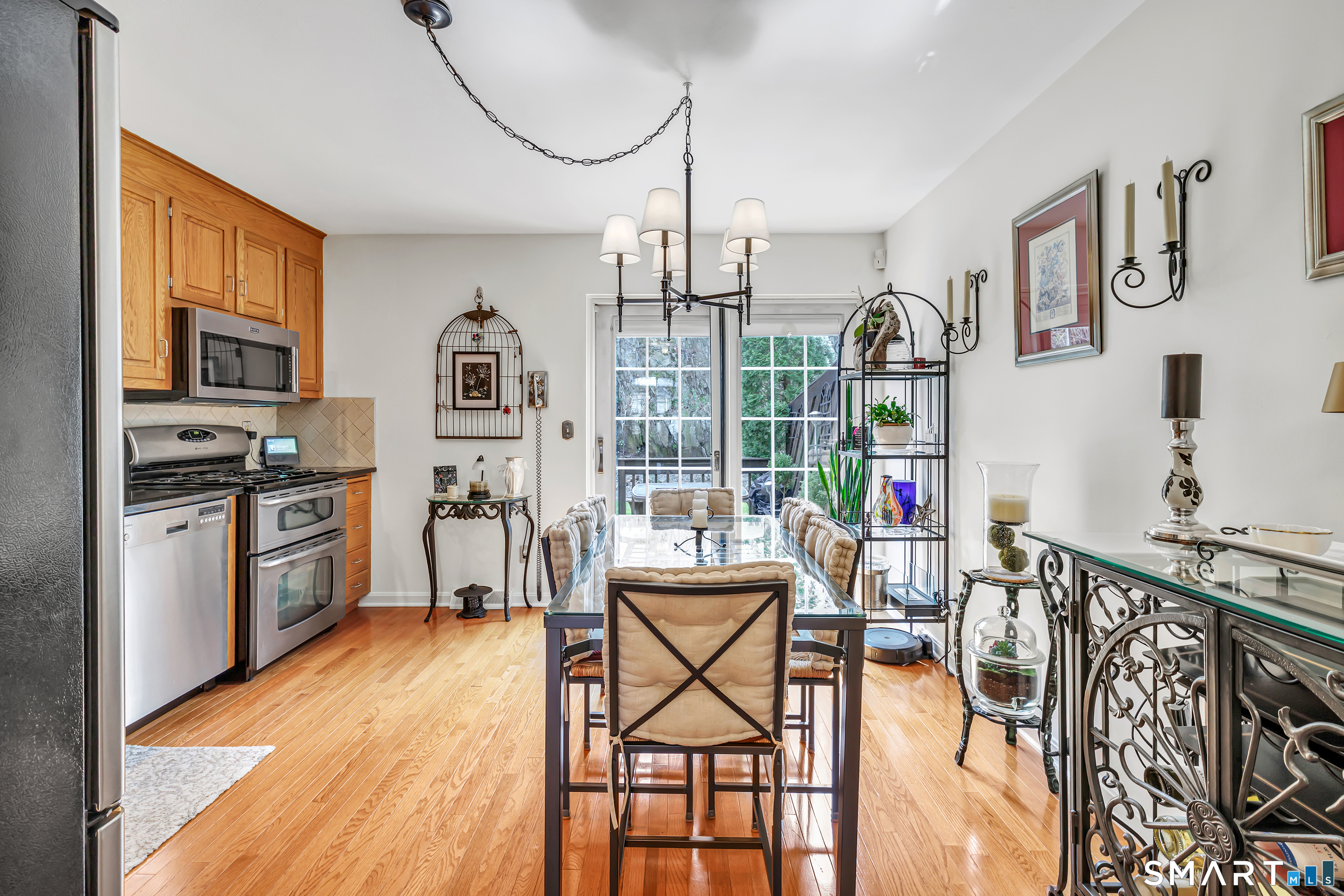 146 Howe Avenue, Unit 146 Shelton, CT 06484 - Photo 6 of 35 a kitchen with stainless steel appliances granite countertop a stove top oven a refrigerator a dining table and chairs with wooden floor