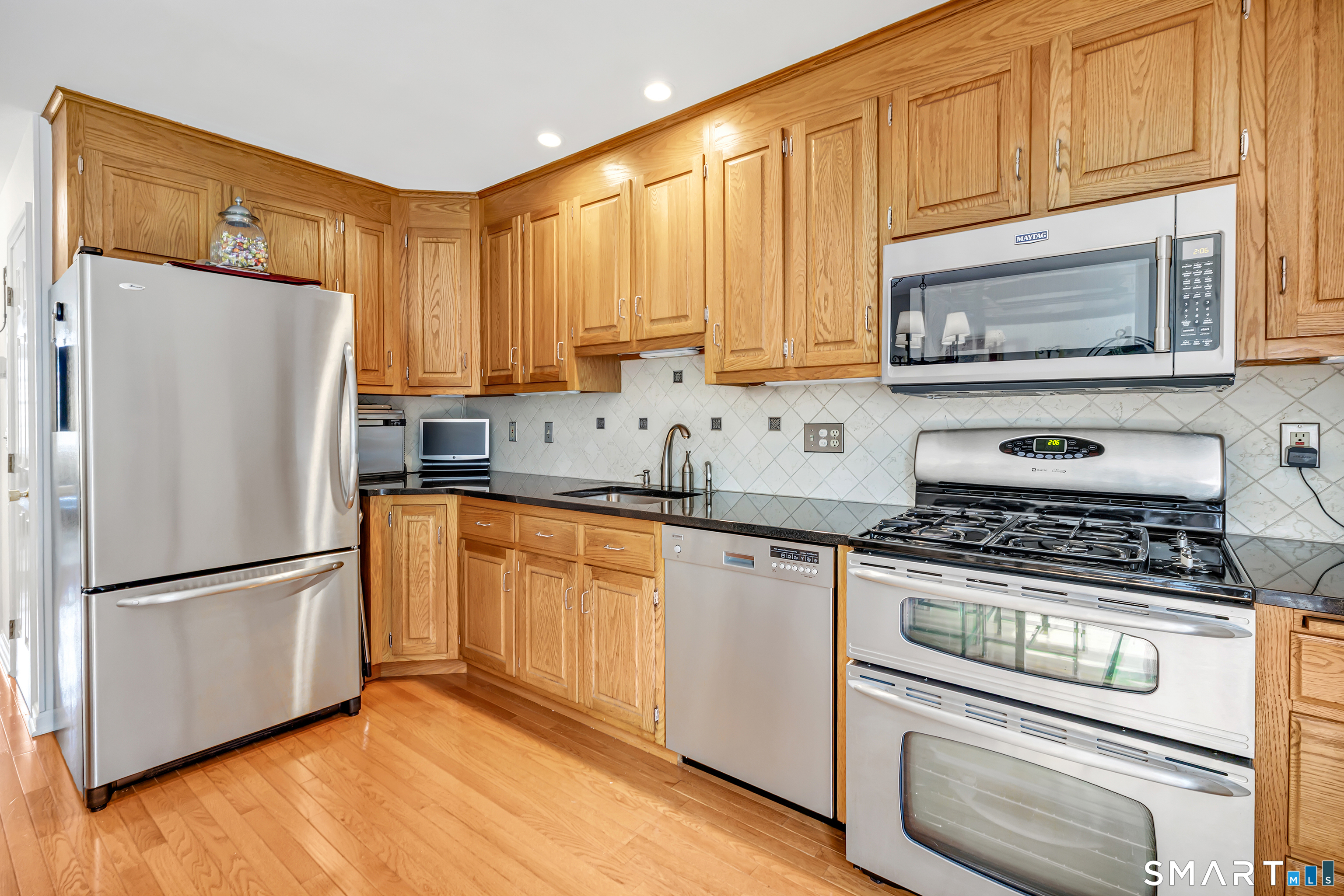 146 Howe Avenue, Unit 146 Shelton, CT 06484 - Photo 8 of 35 a kitchen with granite countertop a refrigerator stove and microwave