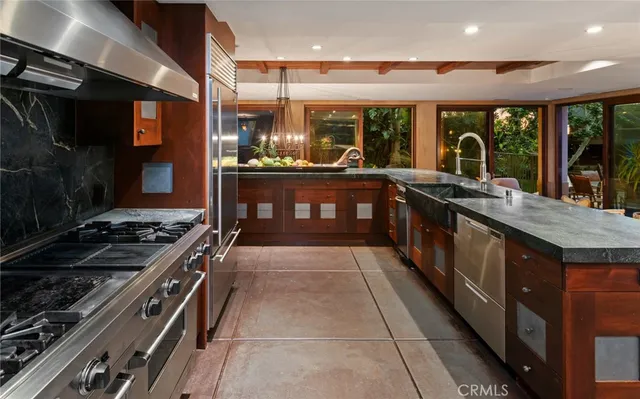 a kitchen with stainless steel appliances granite countertop a stove a sink and a microwave