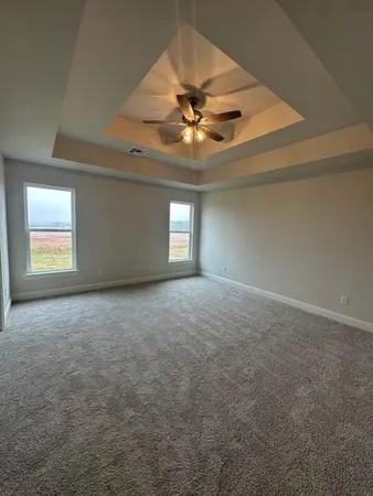 an empty room with a ceiling fan and window