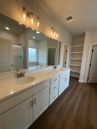a spacious bathroom with a double vanity sink and a mirror