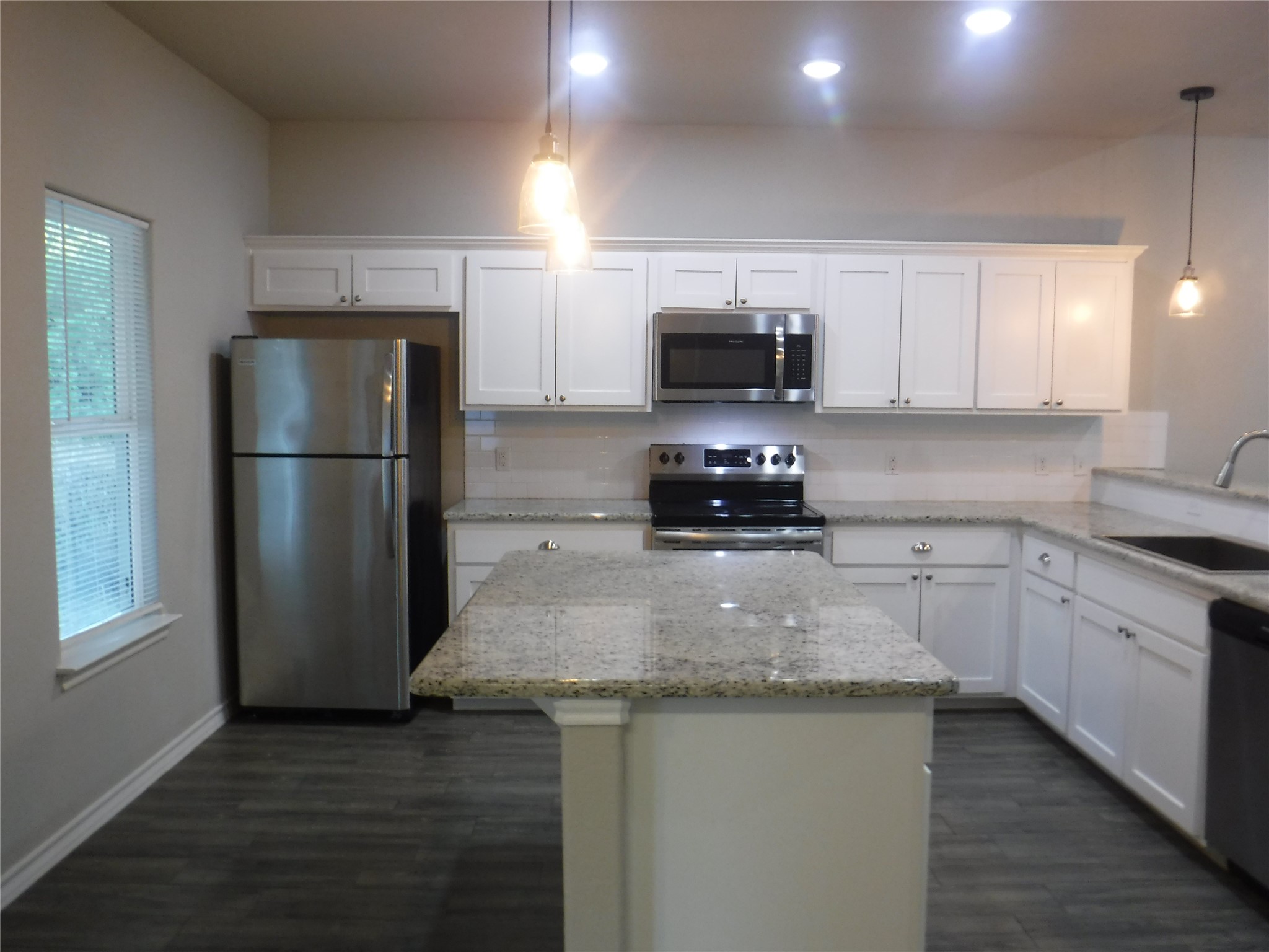 1633 Cree Trail Kingsland, TX 78639 - Photo 7 of 11 Kitchen featuring appliances with stainless steel finishes, white cabinetry, a center island, decorative light fixtures, and recessed lighting