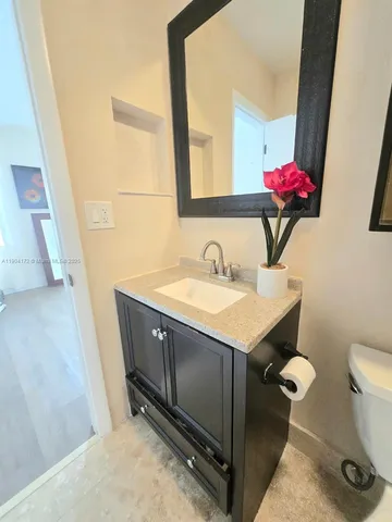 a bathroom with a sink vanity and a toilet