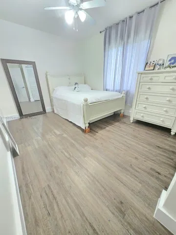 a spacious bedroom with a bed and a dresser