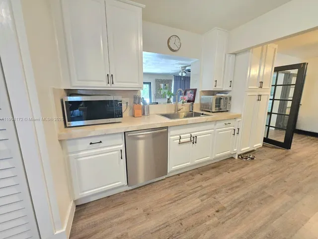 a kitchen with white cabinets stainless steel appliances and sink