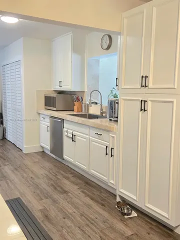 a view of cabinets a sink and dishwasher in a white cabinet