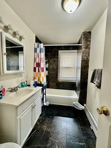 a bathroom with a bathtub sink and mirror