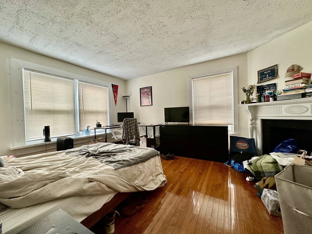 74 Ashford Street, Unit 2 Boston, MA 02134 - Photo 9 of 23 a bedroom with a bed and a fireplace