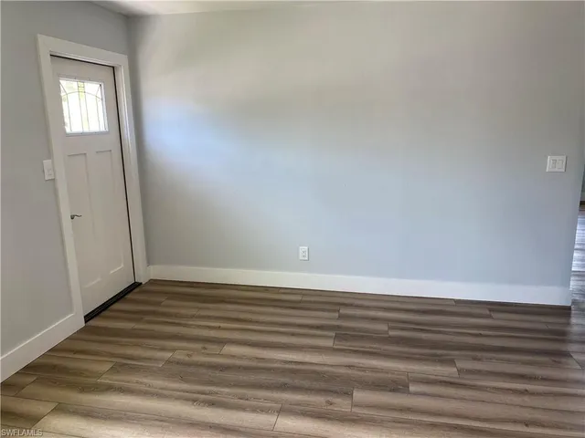a view of a small space with wooden floor and a window