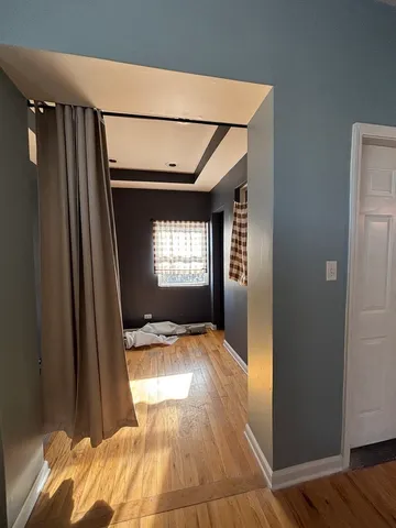 a view of empty room with wooden floor and fan