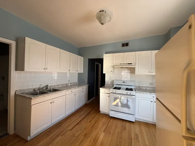 a kitchen with stainless steel appliances granite countertop wooden cabinets and a stove