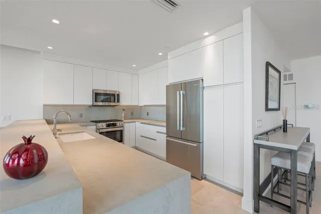 a living room with furniture a flat screen tv and kitchen view
