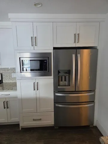a kitchen with white cabinets and stainless steel appliances