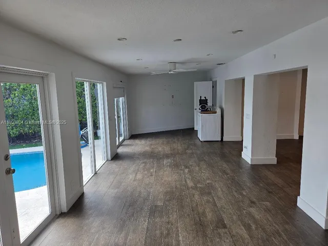 a view of a room with wooden floor and white walls