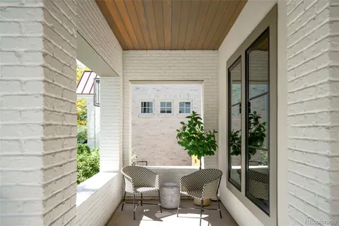a view of a porch with chairs and potted plants