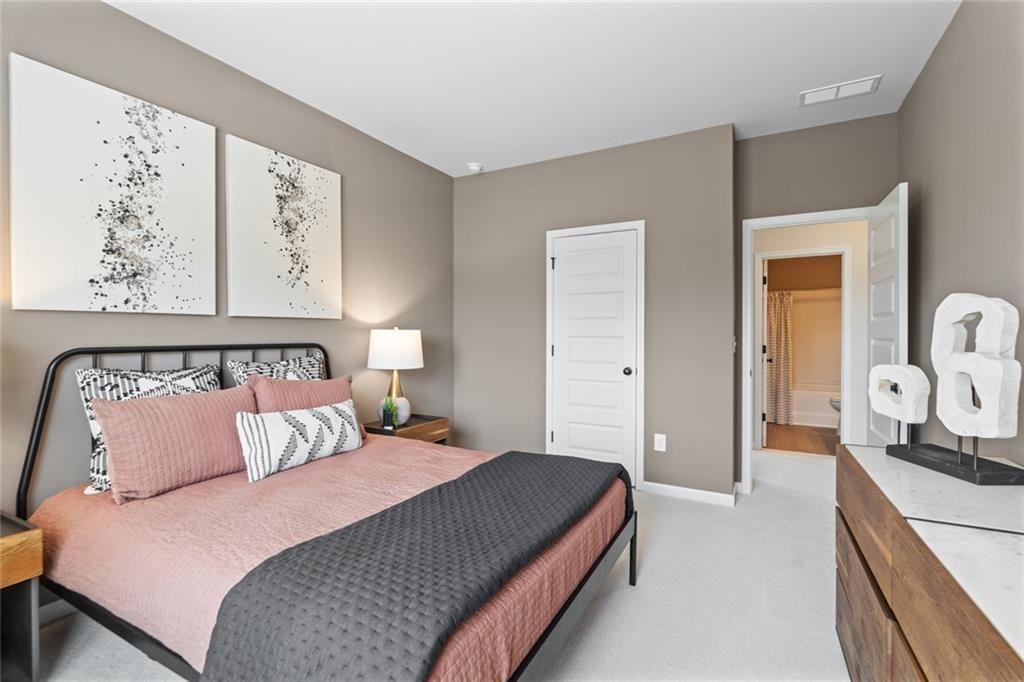 235 Bastian Drive, Unit 17 Villa Rica, GA 30180 - Photo 22 of 30 a bedroom with a large bed and a chandelier