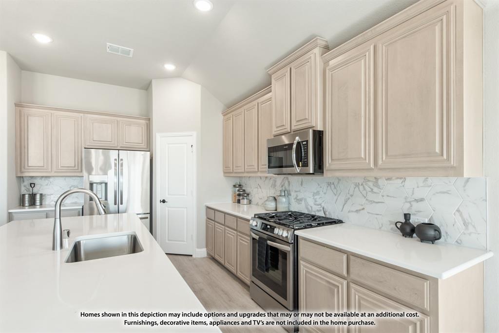 1152 Hitching Post Way Oak Point, TX 75068 - Photo 23 of 36 a kitchen with stainless steel appliances granite countertop a sink stove and cabinets