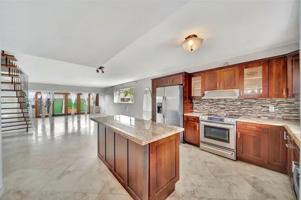 a kitchen with stainless steel appliances granite countertop a refrigerator and a sink