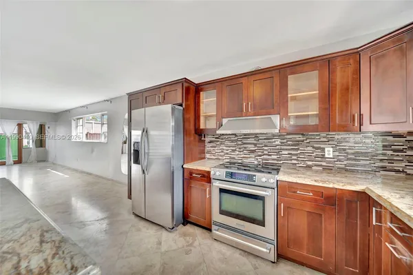 a kitchen with stainless steel appliances granite countertop a sink stove and cabinets