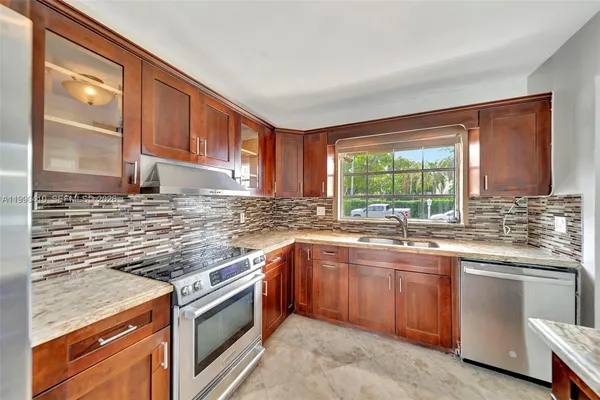 a living room with furniture a large window and wooden floor