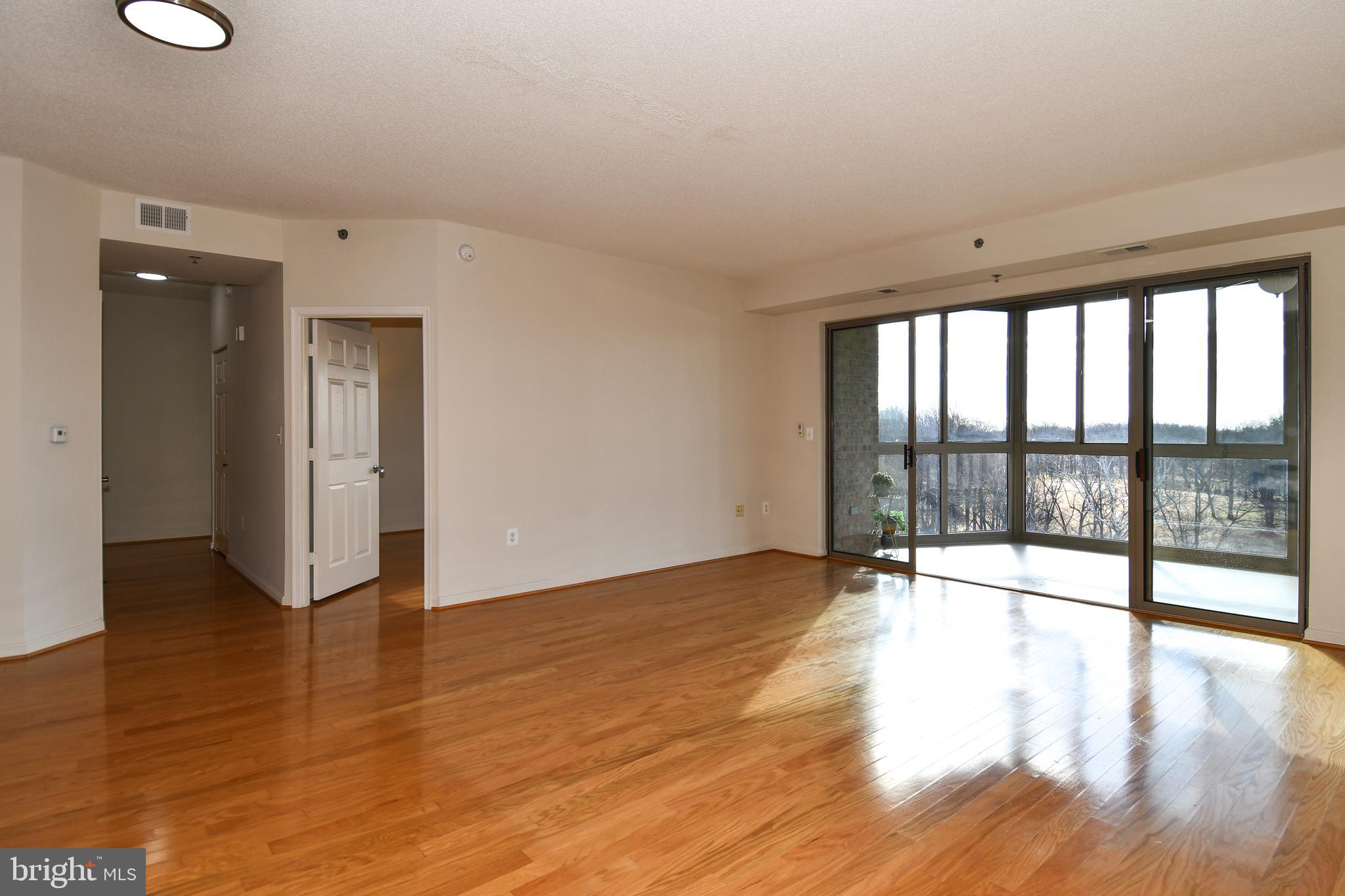 3100 North Leisure World Boulevard, Unit 801 Silver Spring, MD 20906 - Photo 11 of 69 a view of an empty room with wooden floor and a window
