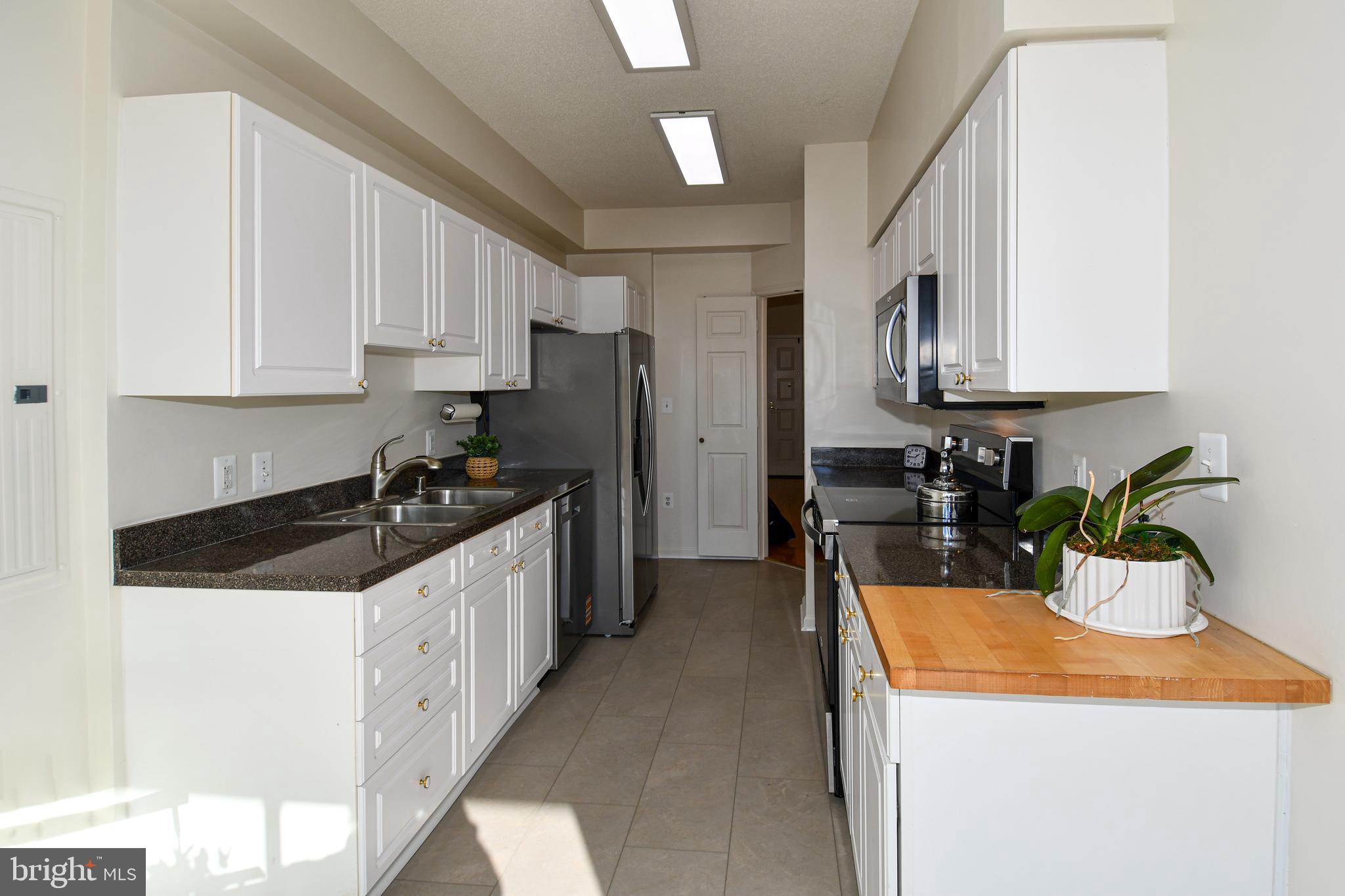3100 North Leisure World Boulevard, Unit 801 Silver Spring, MD 20906 - Photo 21 of 69 a kitchen with granite countertop a sink a stove and refrigerator