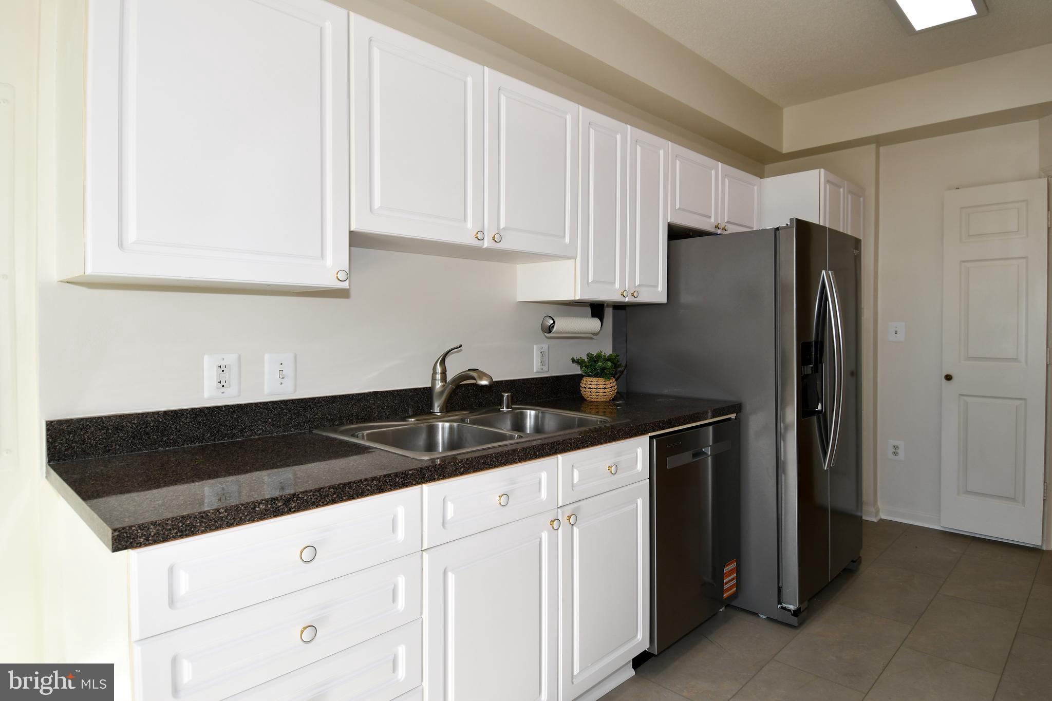 3100 North Leisure World Boulevard, Unit 801 Silver Spring, MD 20906 - Photo 22 of 69 a kitchen with granite countertop white cabinets and refrigerator