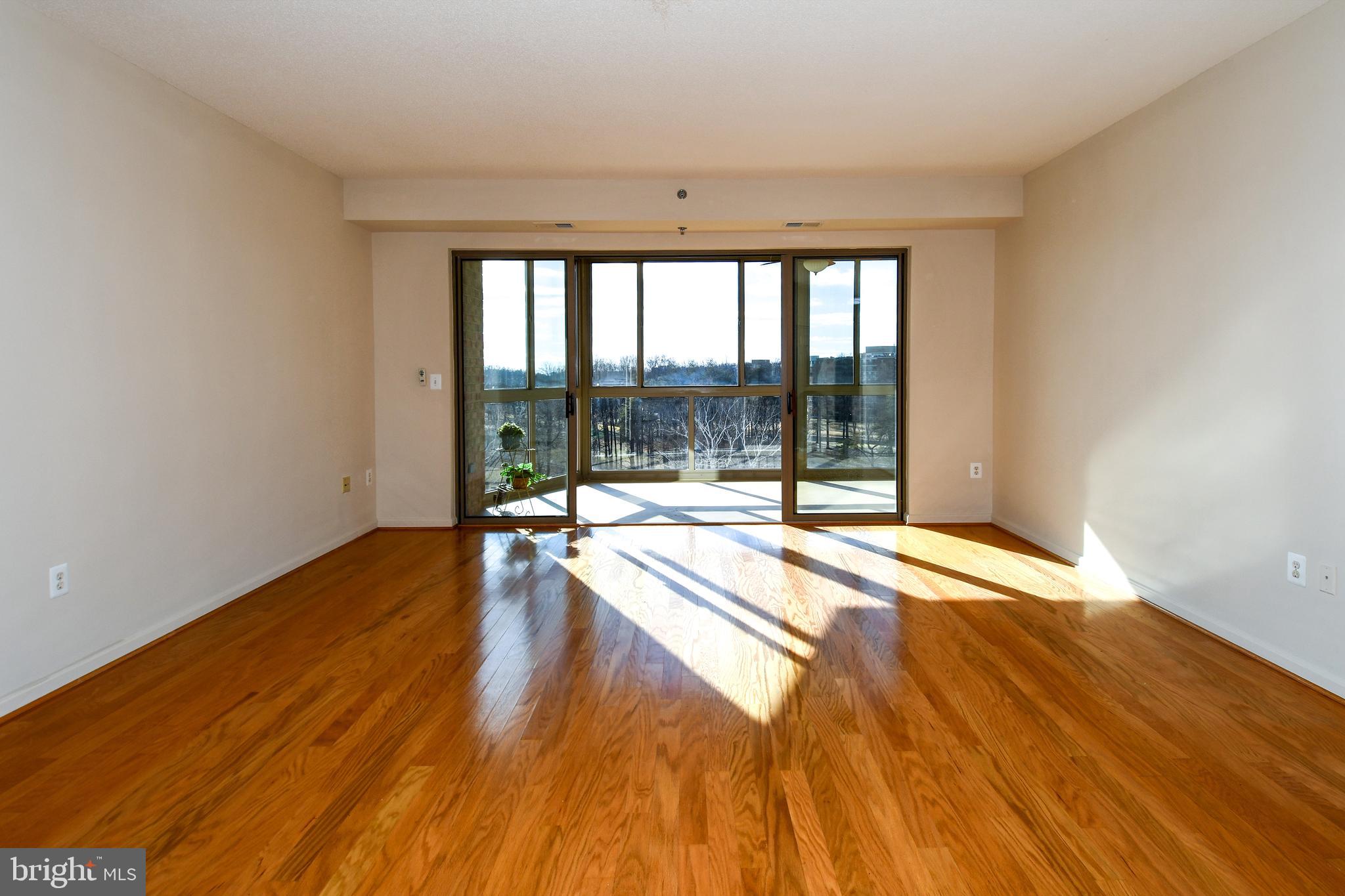 3100 North Leisure World Boulevard, Unit 801 Silver Spring, MD 20906 - Photo 8 of 69 a view of an empty room with wooden floor and a window