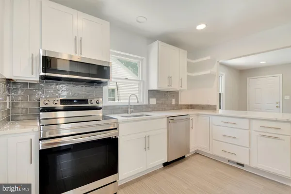 a kitchen with granite countertop white cabinets and appliances