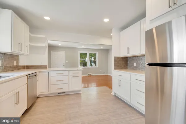 a kitchen with white cabinets and refrigerator