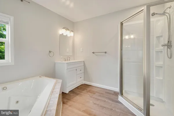 a bathroom with a tub sink and mirror