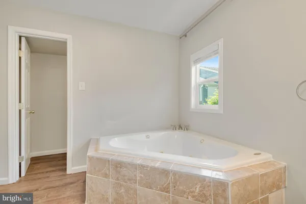 a bath tub sitting in a bathroom next to a window